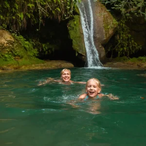 vacancesguadeloupe__mom-and-daughter-at-a-waterfall-in-the-jungle-tra-2026-01-09-07-26-04-utc